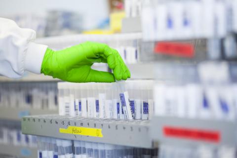 Lab shelves with gloved hand